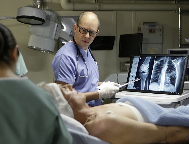 "Stop the Bleeding" -- Gibbs (Mark Harmon) fights for his life aboard a Navy hospital ship after being shot, while DiNozzo and Joanna Teague travel to Shanghai to try and take down the Calling, on the 13th season premiere of NCIS, Tuesday, Sept. 22 (8:00-9:00 PM, ET/PT), on the CBS Television Network. Jon Cryer (Pictured holding chart) begins a multi-episode arc as Gibbs' surgeon, Dr. Cyril Taft. Photo: Sonja Flemming/CBS é2015 CBS Broadcasting, Inc. All Rights Reserved