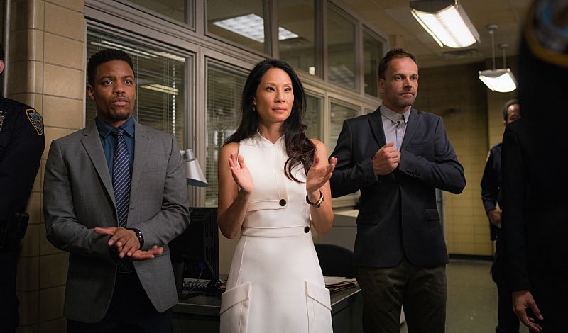 "Henny Penny the Sky is Falling" -- Captain Gregson lobbies to include Holmes and Watson when his unit is selected to receive a city commendation for its exemplary work. Also, as Holmes and Watson consult on the investigation into a financial analyst's murder, they are drawn into the world of asteroid research, on the 100th episode of ELEMENTARY, Sunday, Oct. 30 (10:00-11:00 PM, ET/PT) on the CBS Television Network. Pictured (L-R) Jon Michael Hill as Detective Marcus Bell, Lucy Liu as Joan Watson and Jonny Lee Miller as Sherlock Holmes Photo: Michael Parmelee/CBS é2016 CBS Broadcasting, Inc. All Rights Reserved