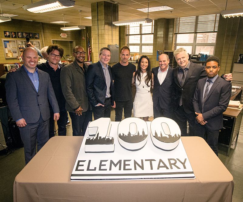 The cast of ELEMENTARY celebrates their milestone 100th episode with a cake-cutting ceremony Pictured (L-R) Bridget Wiley Executive Vice President, Current Programs, CBS Entertainment and CBS Television Studios, Glenn Geller President, CBS Entertainment, Executive Producers John Polson, Carl Beverly, Rob Doherty, Jonny Lee Miller Lucy Liu, David Stapf President, and CBS Television Studios Aidan Quinn, Jon Michael Hill and Kim Metcalf Photo: JEFF NEIRA /CBS é2016 CBS Broadcasting Inc. All Rights Reserved.