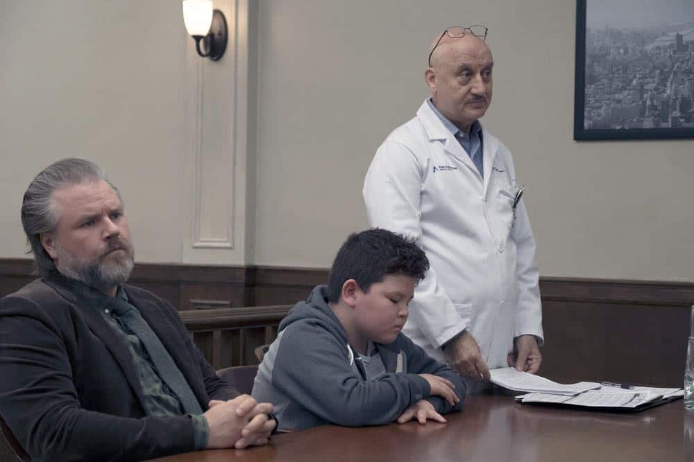 NEW AMSTERDAM -- "Rituals" Episode 102 -- Pictured: (l-r) Tyler Labine as Dr. Iggy Frome, Finn Egan-Liang as Leo Chen, Anupam Kher as Dr. Vijay Kapoor -- (Photo by: Francisco Roman/NBC)