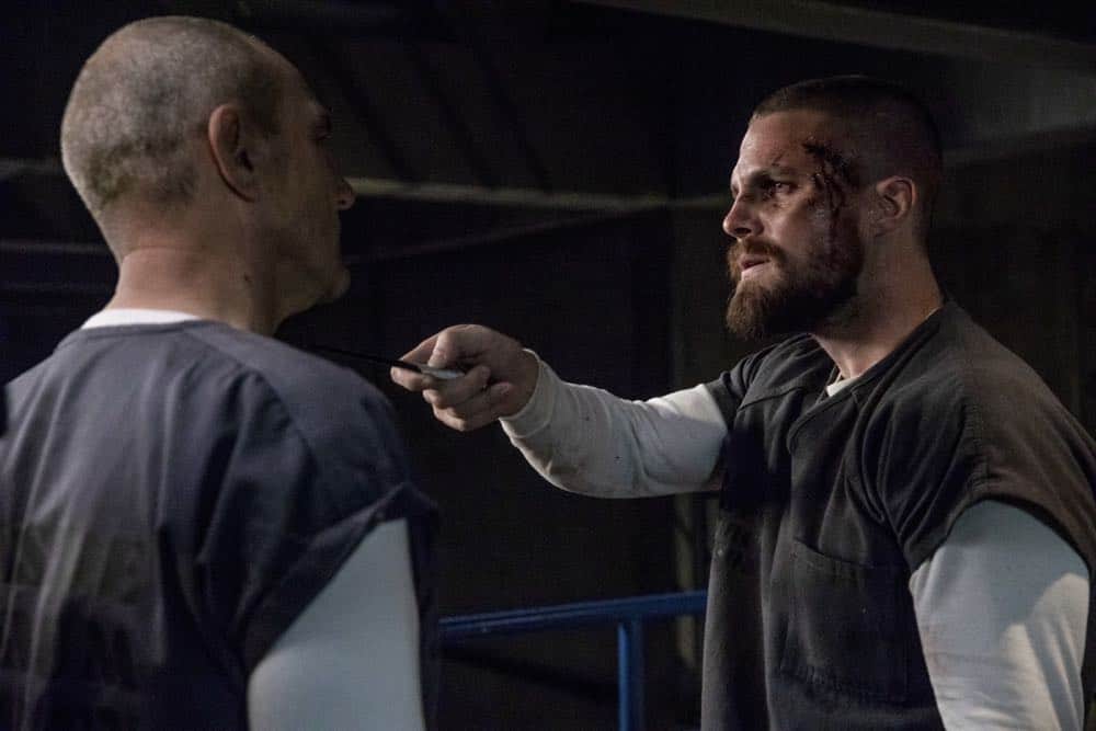 Arrow -- "Crossing Lines" -- Image Number: AR703a_0200b -- Pictured (L-R): Vinnie Jones as Danny "Brick" Brickwell and Stephen Amell as Oliver Queen/Green Arrow -- Photo: Jack Rowand/The CW -- é 2018 The CW Network, LLC. All Rights Reserved.